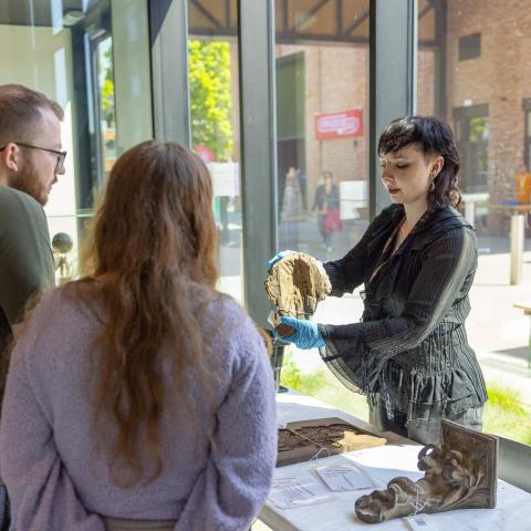 Twee geïnteresseerde bezoekers luisteren naar uitleg over de aantasting van een bepaald stuk.