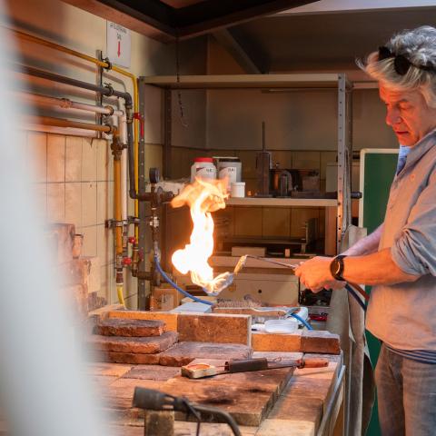 Edelsmit verhit metaal onder een grote vlam